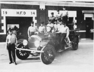Firefighters with an early fire engine, 1923