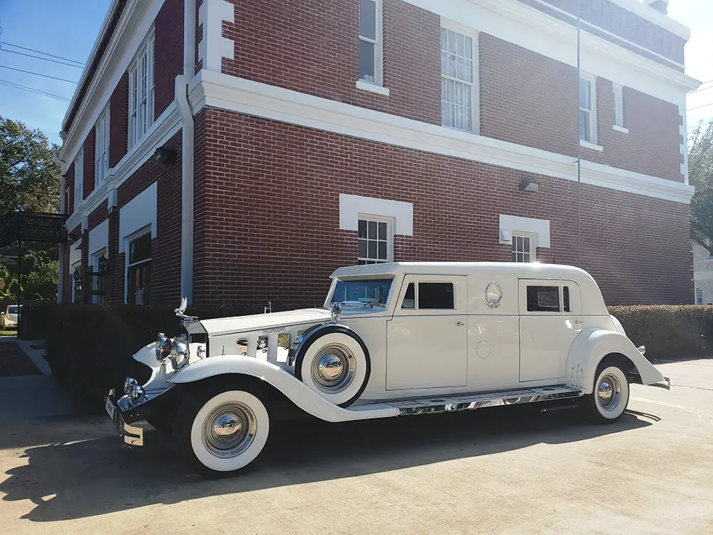 A vintage car in front of the station