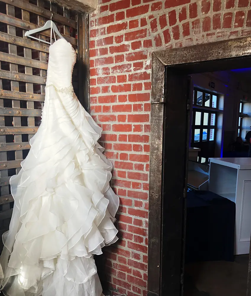 A wedding dress hanging by the original brick jailhouse door